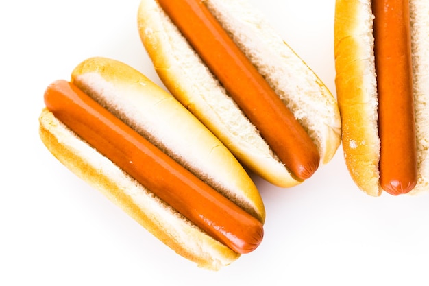 Hot-dogs traditionnels sur un pain à hot-dog blanc sur fond blanc.