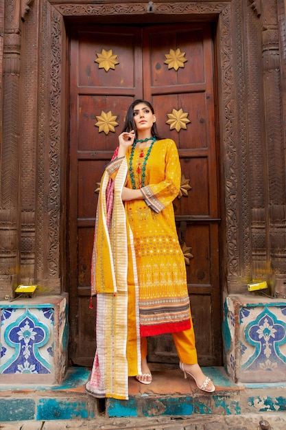 Hot Girl Wearing Yellow Full Desi Dress pour Fashion Shoot devant la vieille porte en bois