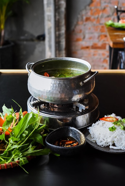 Hot pot coréen avec de la viande de poulet et des nouilles sur fond noir