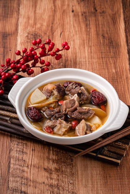 Photo hot pot de mouton frais et délicieux avec des légumes et des plantes médicinales chinoises comme la baie de goji et l'angélique chinoise dong quai.