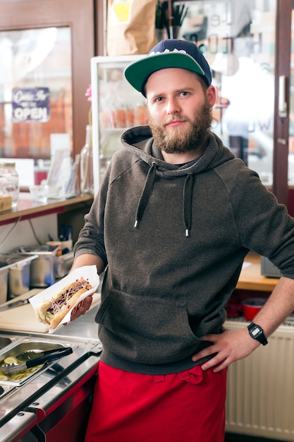 Hotdog - vendeur sympathique et ingrédients frais dans un snack-bar de restauration rapide