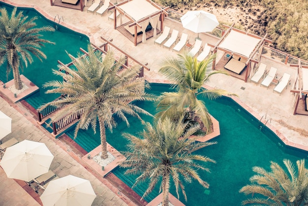 Hôtel au bord de la piscine avec parasols et palmiers Top view shot