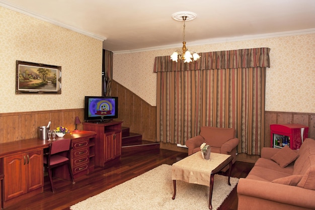 Un hôtel avec des chambres de style rétro à l'ancienne et des objets rustiques canapé et chaises et télévision