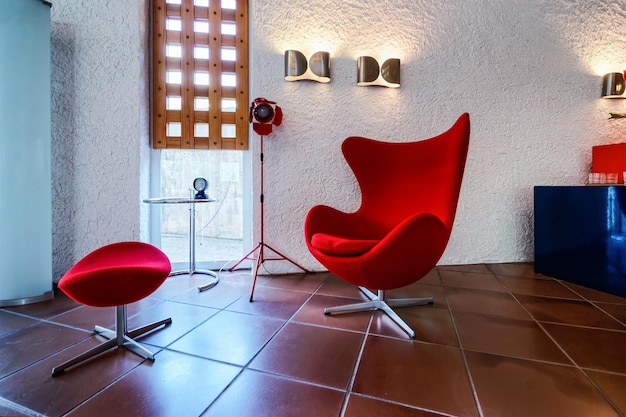 Hôtel italien moderne avec fauteuil rouge dans le hall. Salon avec mobilier de séjour de maison ou appartement. Intérieur du bureau d'affaires avec design de décoration. Espace à la réception en Italie.