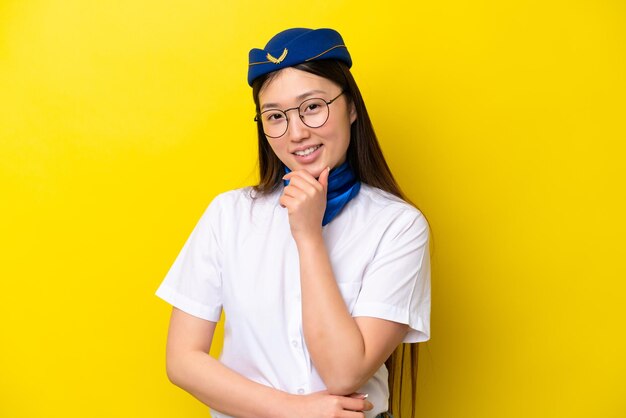Hôtesse de l'air femme chinoise avion isolé sur fond jaune avec des lunettes et souriant