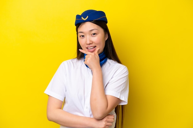 Hôtesse de l'air femme chinoise avion isolé sur fond jaune souriant