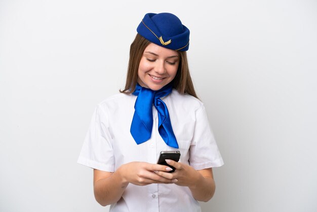 Hôtesse de l'air femme lituanienne avion isolé sur fond blanc l'envoi d'un message avec le mobile