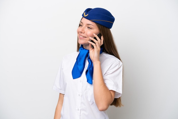 Hôtesse de l'air femme lituanienne avion isolé sur fond blanc en gardant une conversation avec le téléphone mobile avec quelqu'un