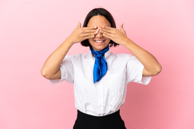 Hôtesse de l'air sur fond isolé couvrant les yeux par les mains et souriant