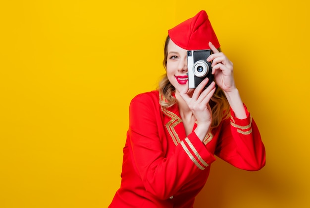 hôtesse de l&#39;air portant un uniforme rouge avec appareil photo