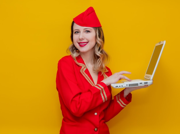 hôtesse de l&#39;air portant un uniforme rouge avec ordinateur portable
