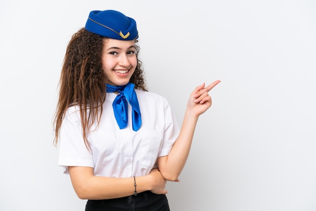 Hôtesse de l'avion femme arabe isolée sur fond blanc pointant le doigt sur le côté