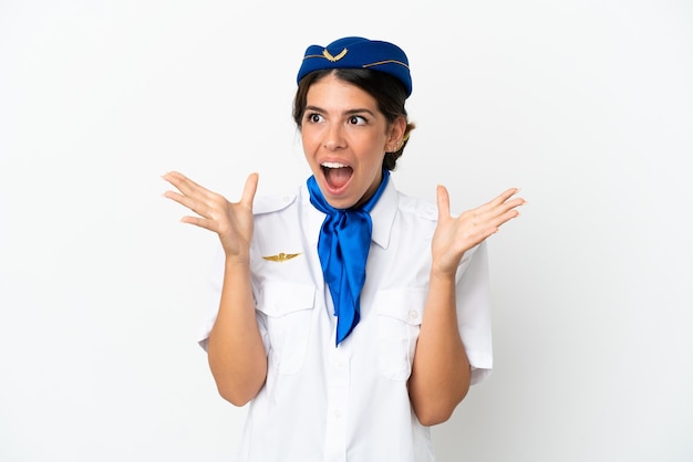 Hôtesse d'avion femme caucasienne isolée sur fond blanc avec une expression faciale surprise