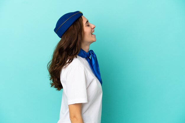 Hôtesse D'avion Femme Isolée Sur Fond Bleu En Riant En Position Latérale