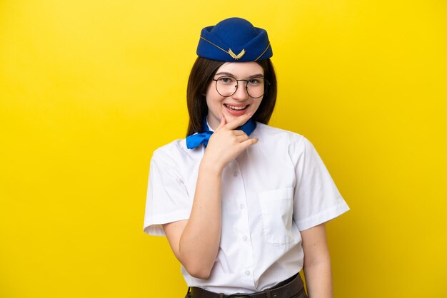 Hôtesse de l'avion femme russe isolée sur fond jaune avec des lunettes et souriant