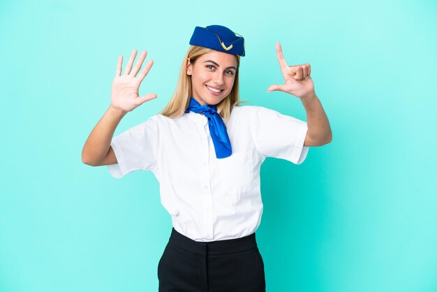 Photo hôtesse de l'avion femme uruguayenne isolée sur fond bleu comptant sept avec les doigts