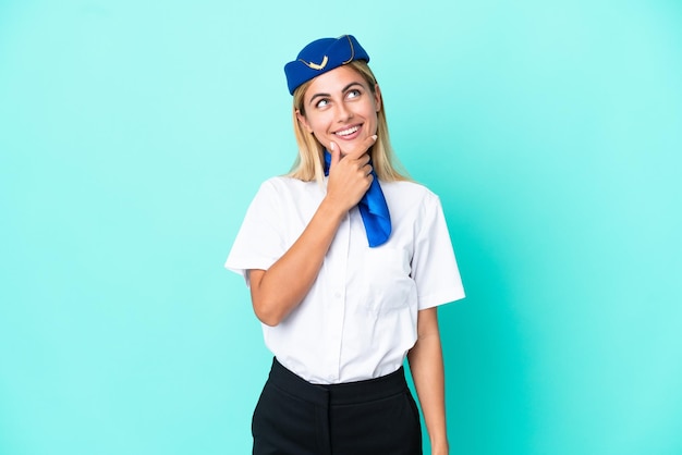 Hôtesse d'avion femme uruguayenne isolée sur fond bleu regardant sur le côté