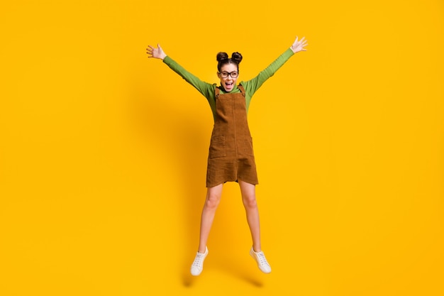 hoto de fille joyeuse jump wear sur fond de couleur jaune
