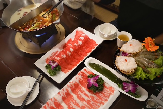 Hotpot chinois shabu soupe épicée et aigre avec de la viande et des fruits de mer, style chinois Suki - selective focus