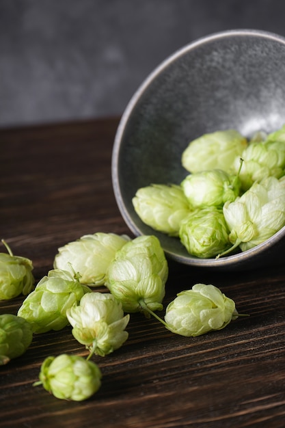 Photo houblon dans un bol sur un espace en bois. fermer.