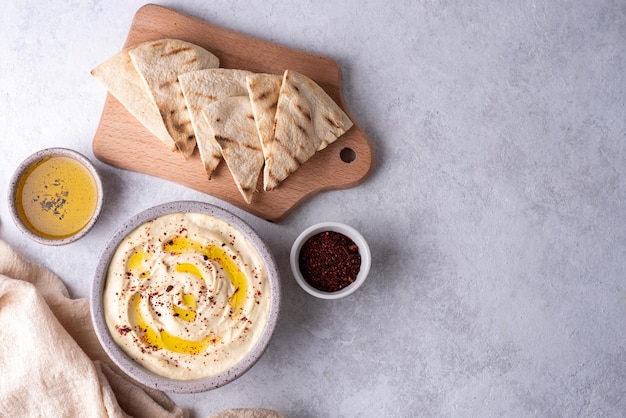 Houmous assaisonné d'huile d'olive avec du pain pita.