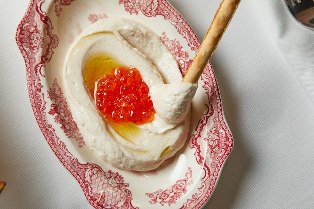 Houmous au caviar rouge sur une belle vue de dessus d'assiette