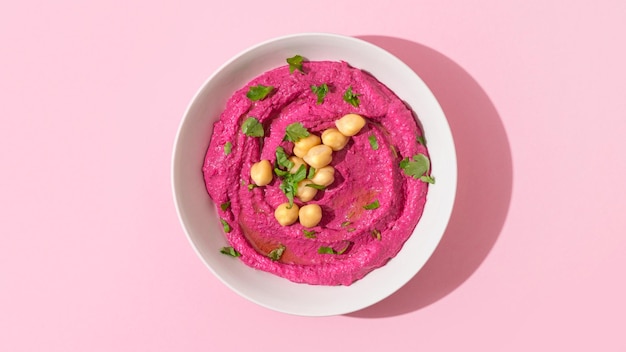 Houmous de betterave sur fond rose vue de dessus