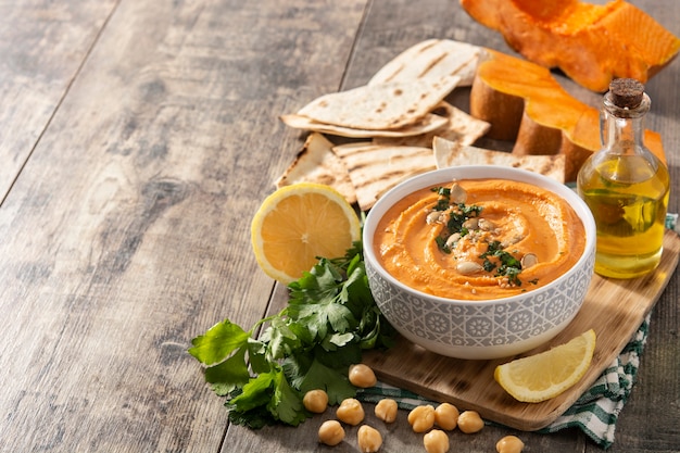 Houmous de citrouille et ingrédients sur table en bois