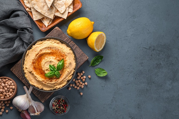 Houmous et ingrédients sur fond sombre, nourriture saine orientale