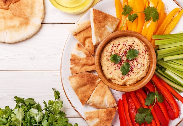 Houmous maison sain avec assortiment de légumes frais et pain pita.