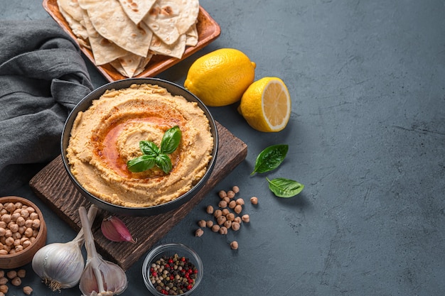 Houmous oriental traditionnel à l'huile d'olive et au paprika sur fond sombre