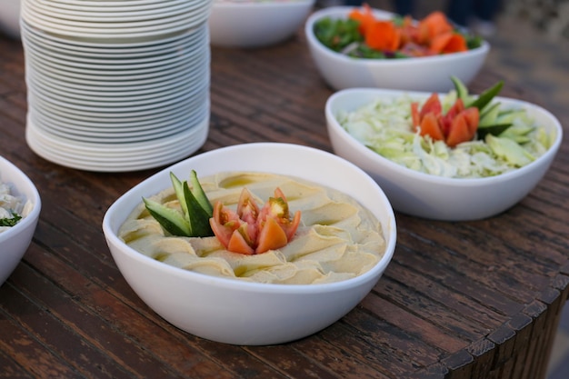 Houmous en plaque blanche sur table en bois. plat arabe