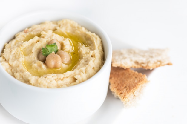 Houmous traditionnel de pois chiche dans un plat à l&#39;huile d&#39;olive.