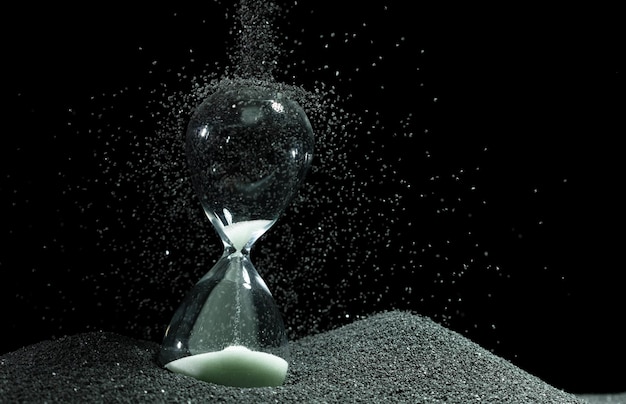 Hourglass ajouter plus de sable du temps sur le sable blanc sur fond noir Hourglass blanc montrer plus de temps Date limite prolongée gestion du temps espoir concept heure horloge de vie de verre passant par