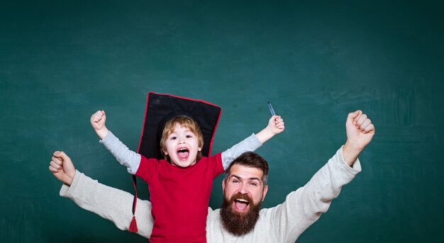 Photo hourra concept d'éducation et d'enseignement enseignant et élève d'école primaire en âge de classe et homme vieillissant enseigne le tableau noir à l'enfant pour copier le texte de l'espace triomphant des bonnes nouvelles