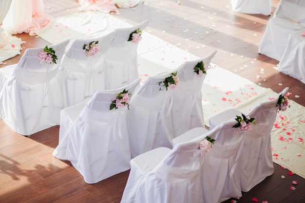 Housses de chaise de mariage avec des fleurs roses