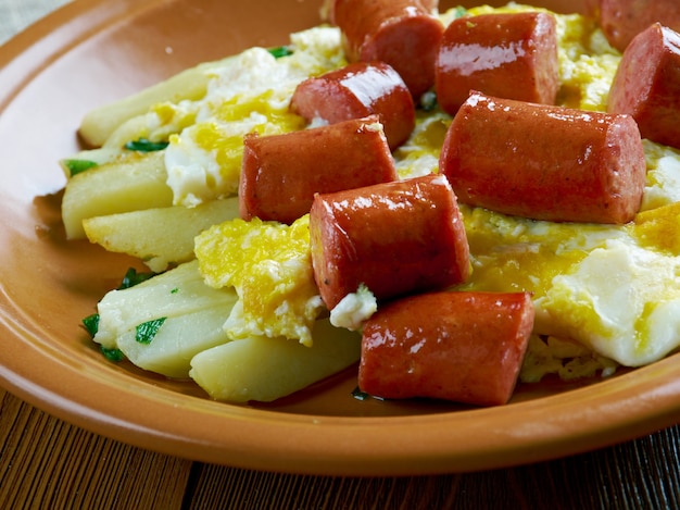 Huevos rotos avec chistorra. Oeufs brouillés avec saucisse et pommes de terre. Style mexicain.