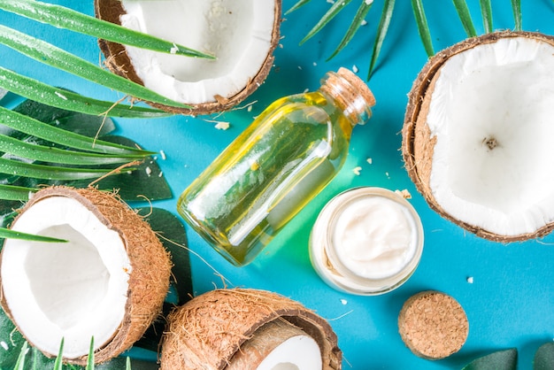 L'huile de coco avec des noix de coco fraîches. Fond d'été tropical