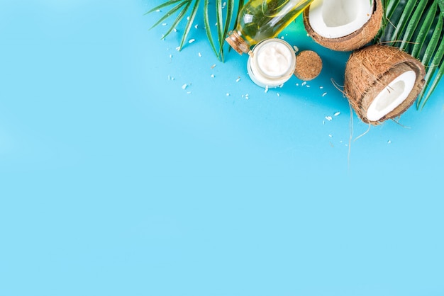 L'huile de coco avec des noix de coco fraîches. Fond d'été tropical