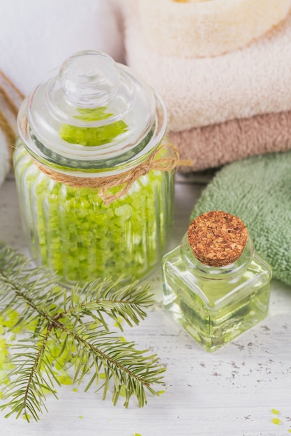 Huile cosmétique naturelle et sel de mer avec extrait de conifère sur fond de bois rustique blanc