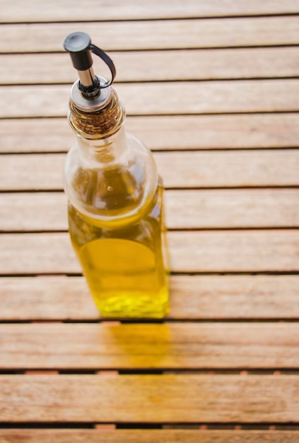 Photo huile dans une bouteille sur une table en bois