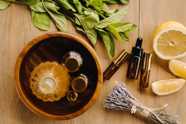 Huile essentielle en bouteilles à l'arôme de menthe citronnée et de lavande posée sur une surface en bois