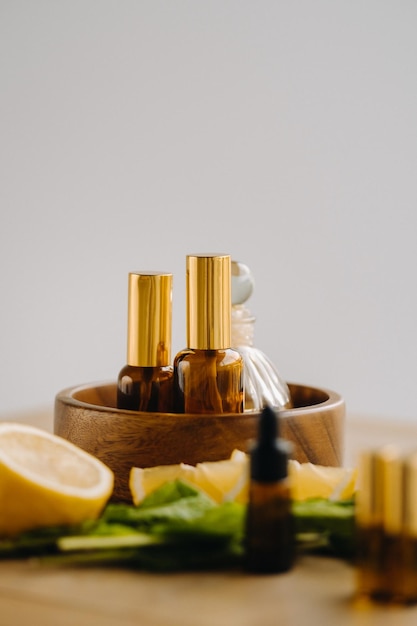 Huile essentielle en bouteilles au parfum de citron et de menthe posée sur une surface en bois