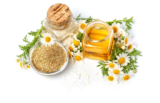 Huile essentielle de camomille dans une bouteille en verre avec des fleurs de camomille fraîches, huile de marguerite parfumée, soin de beauté. Concept de spa