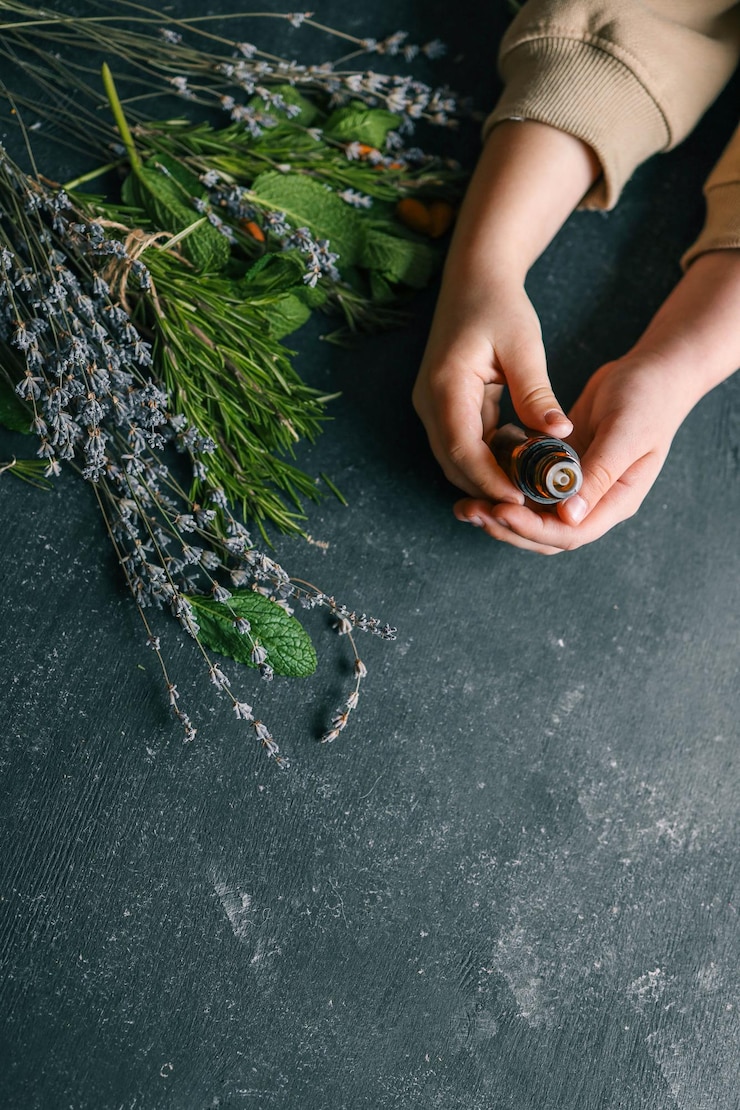 Photo huile essentielle dans les mains en gros plan avec des herbes naturelles