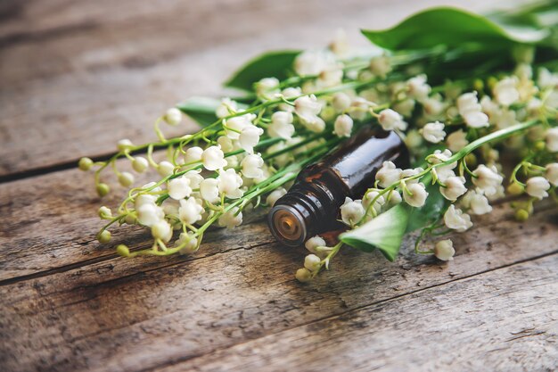 Photo huile essentielle de muguet en petit flacon. mise au point sélective. nature.