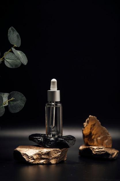 Huile essentielle pour les soins de la peau du visage une bouteille en verre avec une pipette sur une pierre