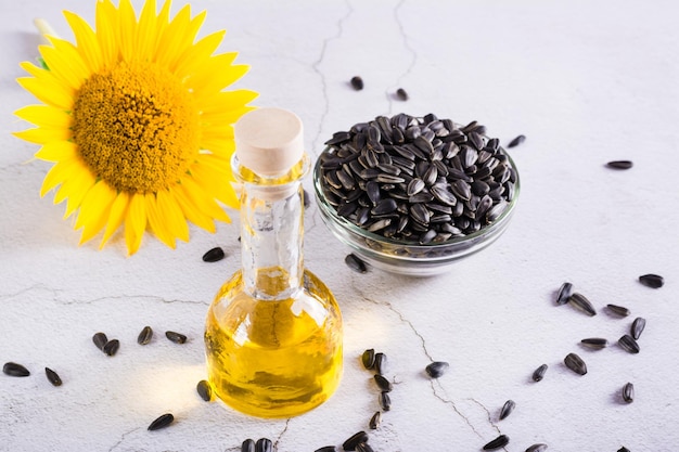 Huile de graines de tournesol dans une bouteille et une fleur sur la table Produits bio