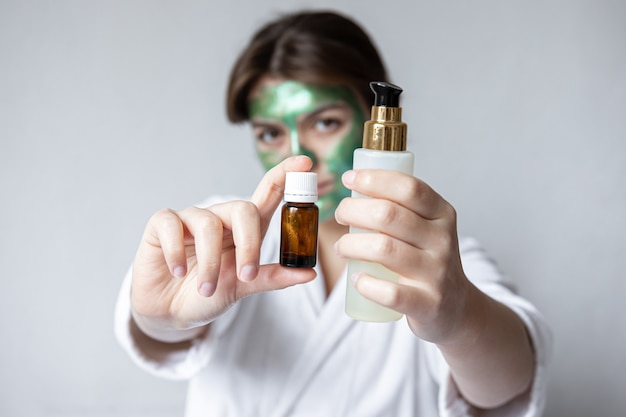 Huile Naturelle Dans Un Pot Et Produit De Beauté Entre Les Mains D'une Jeune Femme, Concept De Choix D'un Produit De Soin Du Visage.