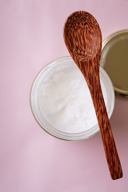 Huile de noix de coco biologique dans le bocal en verre avec cuillère de noix de coco. Concept de durabilité. Vue de dessus. Mise à plat.